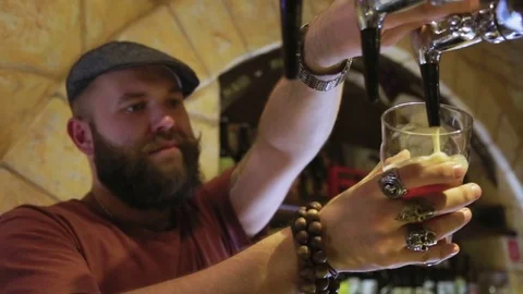 The bearded bartender pours a beer Stock Footage 70528427