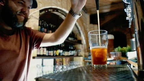 The bearded bartender pours a beer Stock Footage 70528443