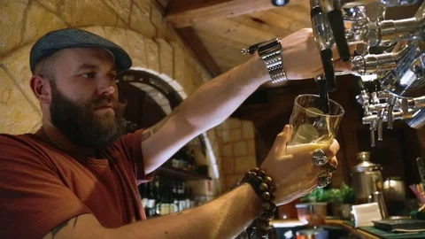 The bearded bartender pours a beer 動画素材 70528465