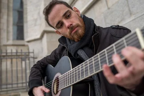 Bearded bearded man learning to play guitar on the street. Hobby concept Stock Photos
