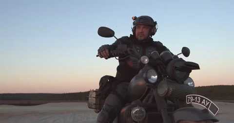 A bearded biker is sitting on a motorcycle Video stock 157102162