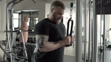 Bearded bodybuilder training on a cable crossover fly pulley in the gym. Stock Footage 85715524