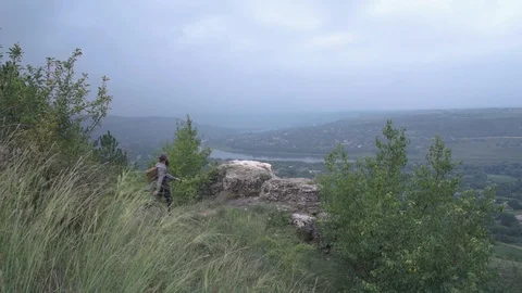 A bearded boy with a backpack and hat reached his destination. A beautiful view Stock Footage 127159279