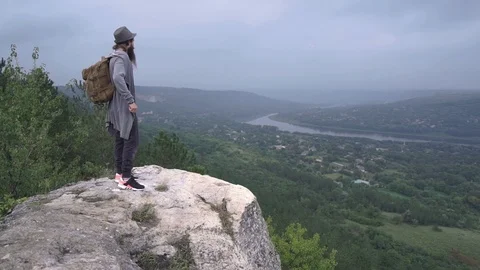 A bearded boy reached his destination on a mountain near a river Stock Footage 127159337
