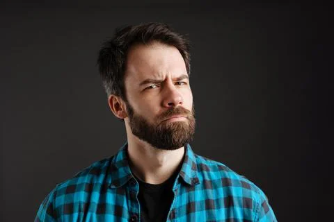 Bearded brooding white man frowning and looking at camera Stock Photos