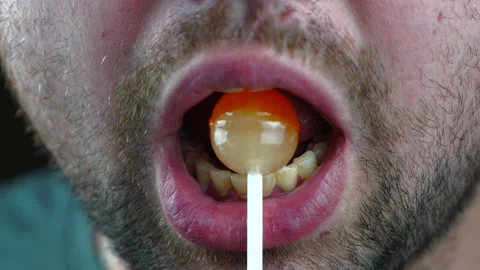 Bearded brutal man licks candy on a stick simulating oral sex Stock Footage 130222205