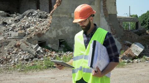 Bearded builder engineer with a tablet and drawings Stock Photos