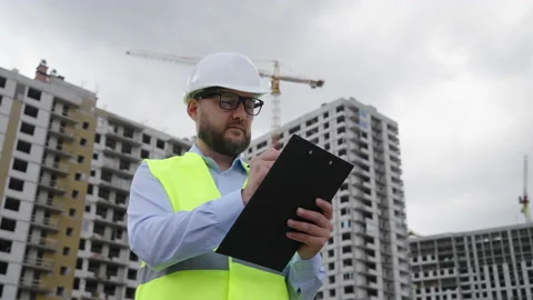Bearded building contractor making notes at construction site Stock Footage 218146757