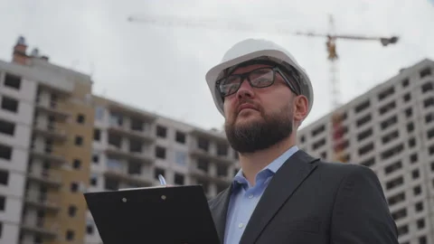 Bearded building engineer making notes at construction site Stock Footage 219776407