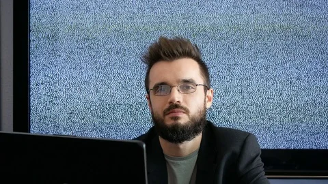 Bearded businessman pointing and using laptop with grainy screen behind 库存影片 73014351