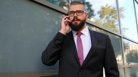 Bearded businessman  using mobile phone outside the office Video stock 60944910