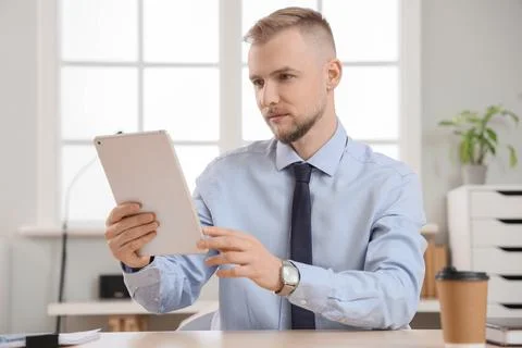 Bearded businessman working with tablet computer at desk in office 스톡 사진