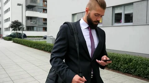 Bearded businessman writting e-mail using his mobile phone. Outdoor photo. Video stock 60944838