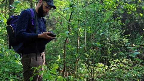 Bearded camper wiping the lens of a trail camera with his sweater Video stock 336971672