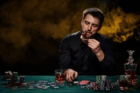 Bearded casino player man playing poker on green table Stock Photos