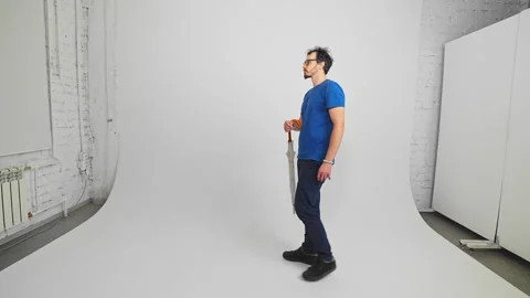 Bearded Caucasian guy is going with closed long umbrella waving it like a cane Stock Footage 343876561