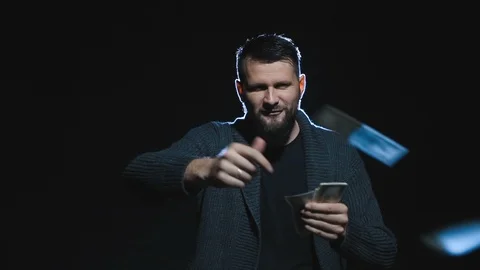 Bearded caucasian man  smiling, making eyes and throwing  money 스톡 동영상 117472496