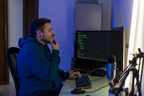 Bearded Caucasian programmer typing on his computer keyboard and thinking how to Foto stock