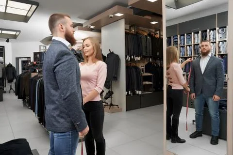 Bearded client looking at mirror and choosing smart suit Stock Photos