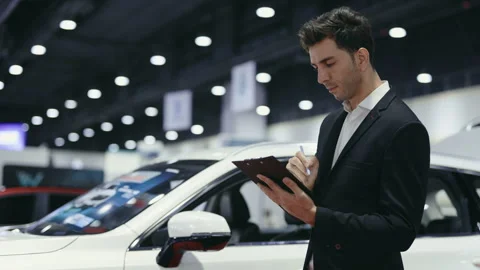 Bearded Consultant Checks the Data on the Car and Writes Them Down. Video stock 265558683
