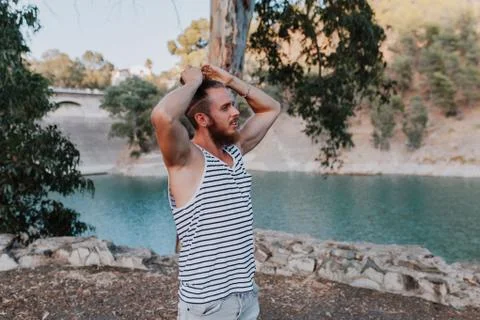 Bearded cool man making himself a long hair pony in nature. Stock Photos
