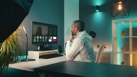 Bearded creator makes video on desktop in his funky home studio. He is Stock Footage 241765327
