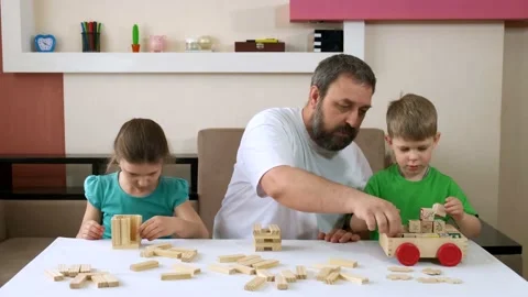 Bearded dad and children play with wooden blocks and toys. Social distancing Video stock 131069759