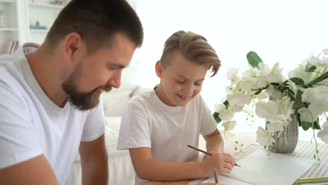 Bearded dad draws comics with his son. Laughter and fun. Creation Stock Footage 115090719