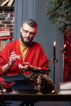 Bearded diviner feeling thoughtful using oracle cards in the evening Stock Photos