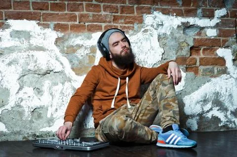 The bearded DJ. The guy in the hat and sneakers. Stock Photos
