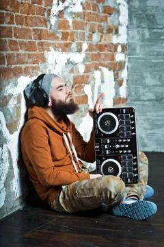 The bearded DJ. The guy in the hat and sneakers. Stock Photos