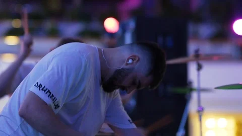 A bearded drummer with an earpiece beats the drum wearily. Stock Footage 126568695
