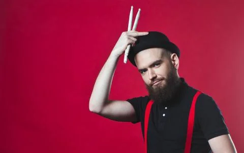 Bearded drummer on a red background Stock Photos