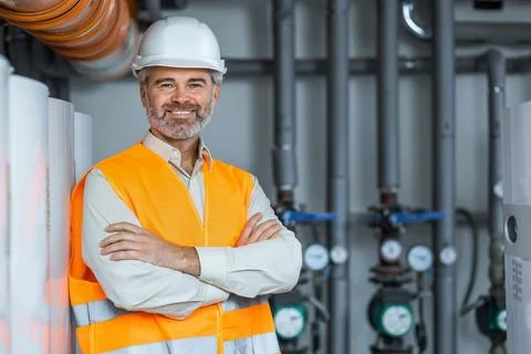 Bearded Engineer Standing and Posing with Crossed Arms in the Middle of a hea 스톡 사진