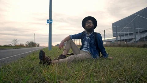 The bearded face of a pretty dressed casually laid down guitar, sitting on the Stock Footage 119600174