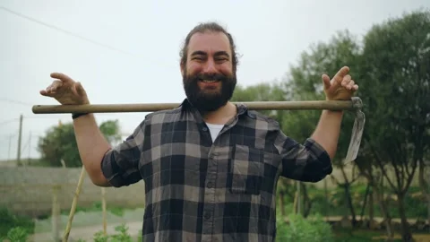 Bearded farmer with hoe behind neck in countryside 스톡 동영상 171431957
