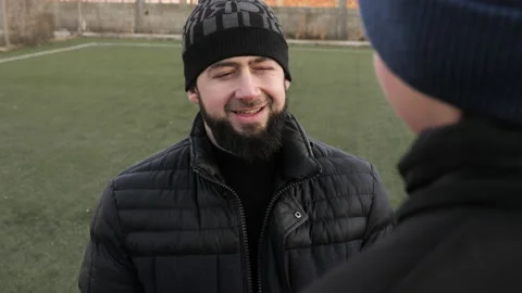 Bearded father talks to son spending time on soccer field Stock Footage 148099665