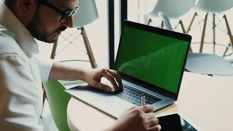 Bearded freelancer using green screened laptop and tablet in the cafe Stock Footage 112994597