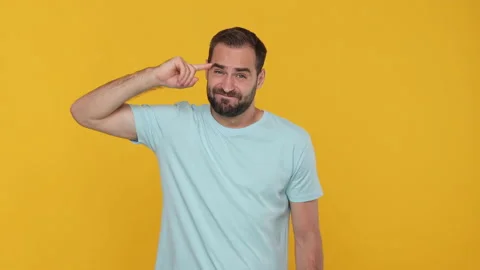 Bearded fun weird young guy 20s in basic casual blue t-shirt isolated on yellow Video stock 148287763