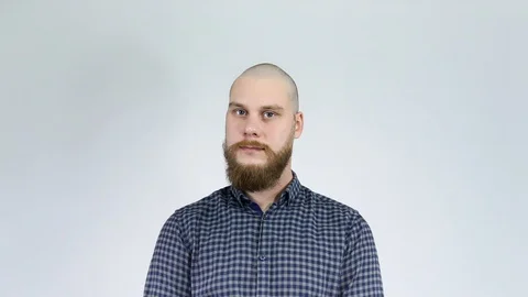 A bearded guy and looks in the mirror at his bald head. Stock Footage 122012415