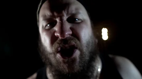 A bearded guy in a baseball cap, yelling something at the camera 스톡 동영상 125355879