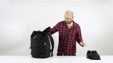 Bearded guy collects things in a suitcase for travel Stock Footage 102891572