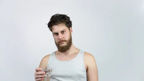 Bearded guy drinking beer and kicks the taste.Man holding a glass with alcohol. Stock Footage 122320596