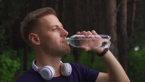 Bearded guy drinking water at a jog Stock Footage 221398966