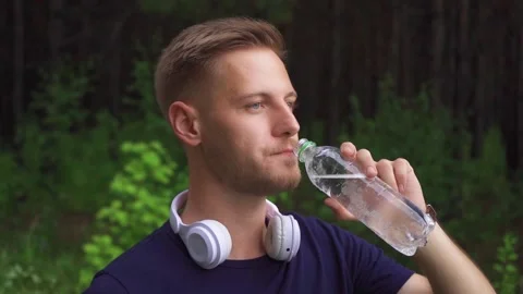 Bearded guy drinking water at a jog Video stock 221399676