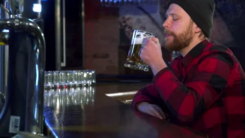 Bearded guy enjoying a cold beer at the pub Stock Footage 311939648