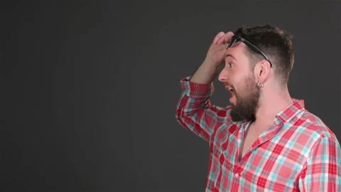 Bearded guy expressing surprise isolated on dark gray background Stock Footage 251464182