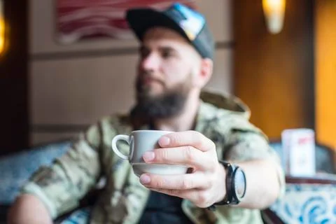 A bearded guy. A guy with a cup of coffee in no focus. Foto stock