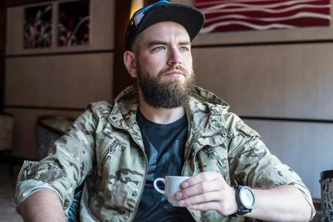 A bearded guy. The guy with a cup of coffee. Stock Photos