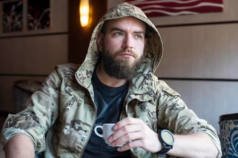 A bearded guy. The guy with a cup of coffee. Stock Photos